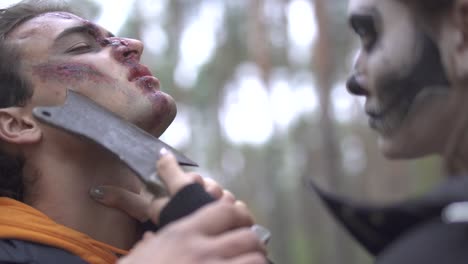 Halloween.-A-girl-with-a-terrible-make-up-threatens-the-guy-with-a-knife