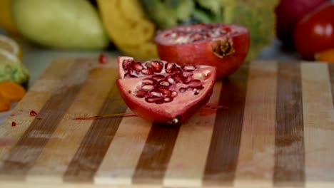 Man-is-cutting-pomegranate-on-cutting-board