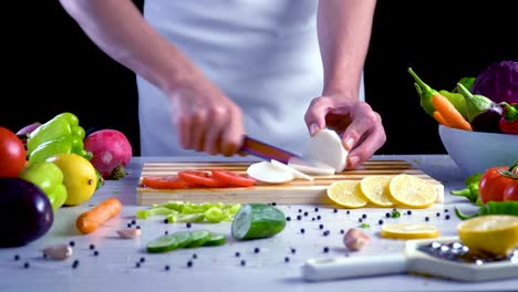 Chef-is-cutting-black-turnip-in-the-kitchen,-slicing-black-radish