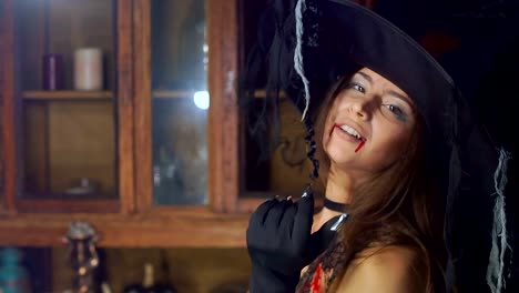 Cerca-de-bruja-de-Halloween-en-un-sombrero.-Se-vuelve-hacia-la-cámara-y-sonríe