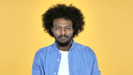 Afro-American-Man-Gesturing-Thumbs-Down-on-Yellow-Background