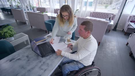 tutoring-for-disabled,-successful-crippled-man-in-wheelchair-with-educator-woman-using-smart-computer-technology-during-personal-lesson