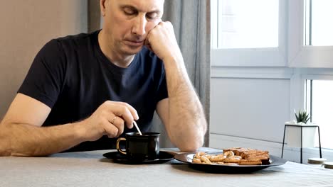 Hombre-adulto-en-la-mañana-en-la-cocina,-pensando-en-sus-problemas.-Él-está-bebiendo-café