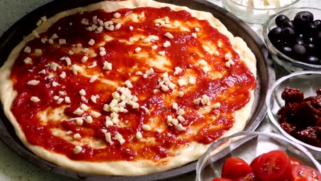 Geriebener-Mozzarella-Käse-verlegen-auf-Pizza-Belag.