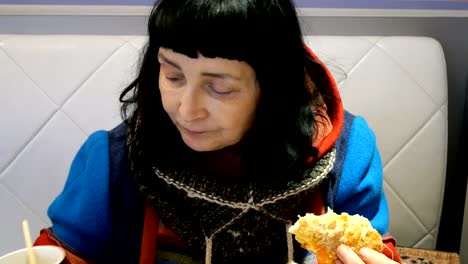 Woman-in-bright-clothes-eats-pizza-and-drinks-coffee.