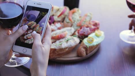 Comida-y-bebida-foto.-Mujer-mirando-fotos-en-la-pantalla-teléfono