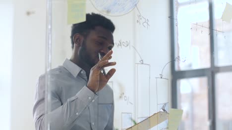 businessman-with-clipboard-at-office-glass-wall