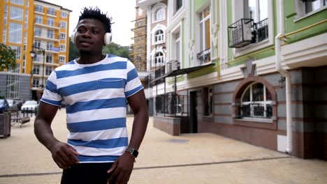 Cheerful-guy-enjoying-afrohouse-music-on-street