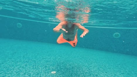 Young-guy-swims-underwater-in-a-swimming-pool