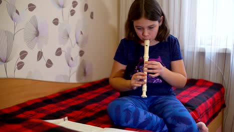 Girl-Sitting-on-the-Bed-and-Playing-Flute