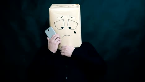 The-concept-of-emotions.-A-man-listens-to-a-message-on-a-smartphone.-He-wipes-tears-on-his-face.-Facial-expression-of-despondency-and-extreme-disappointment.-A-tear-drips.