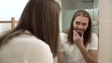 Hombre-en-el-baño-mirando-en-el-espejo-y-tocarse-la-cara