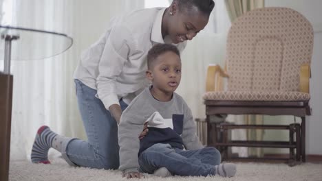 Joyful-African-American-mother-plays-with-her-naughty-child.