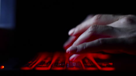 hacker-girl's-hand-typing-on-keyboard-with-red-backlight