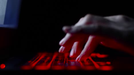 hacker-girl's-hand-typing-on-keyboard-with-red-backlight