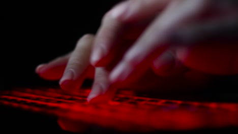 hacker-girl's-hand-typing-on-keyboard-with-red-backlight