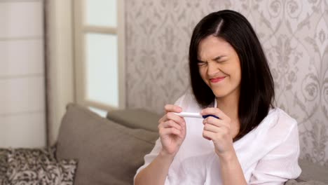 Sad-woman-with-pregnancy-test-at-home