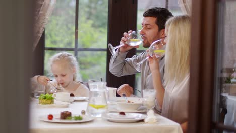 Pareja-casada-y-niño-comiendo-en-el-restaurante