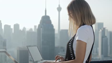 Freelancer-using-laptop-on-modern-city-background.