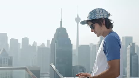 Freelancer-using-laptop-on-modern-city-background.