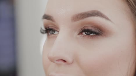 Professionelle-Make-up-Künstler-Frau-malt-Wimpern-an-Kunden-des-Schönheitssalons