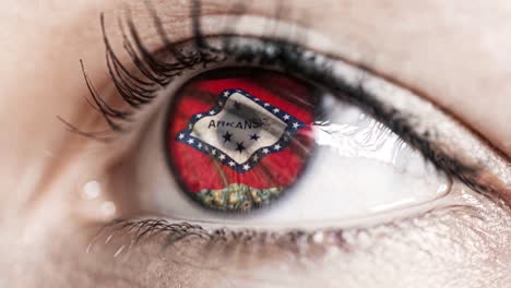 Mujer-ojo-verde-en-primer-plano-con-la-bandera-del-estado-de-Arkansas-en-iris,-estados-unidos-de-América-con-movimiento-de-viento.-concepto-de-vídeo