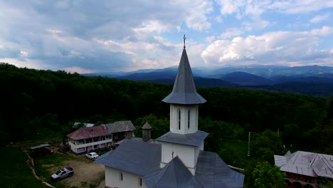 Christian-church-on-top-of-green-hill,-aerial-view,-camera-descending