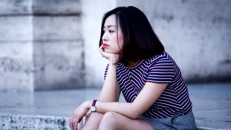 pensive-and-bored-Chinese-woman's-portrait,-sit-on-stairs,-waiting-for-someone