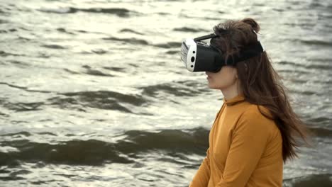 Eine-junge-Frau-nutzt-virtual-Reality-Brille-neben-starken-Wellen.