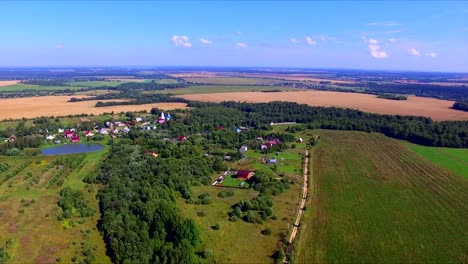 Flug-über-das-Ackerland-mit-Äckern-und-Dorf