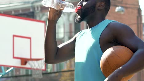 Afro-American-Basketball-Spieler-Trinkwasser-genießen-Sieg-seines-Teams