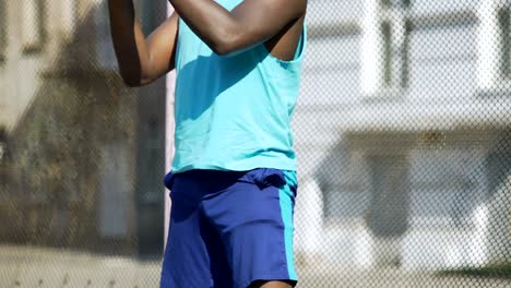 Persona-afro-americana-atlético-flexionando,-preparación-para-el-juego-de-baloncesto,-el-calentamiento