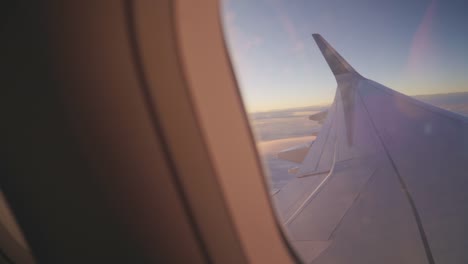 View-through-the-portholes-of-the-plane-to-the-setting-sun-and-the-sky