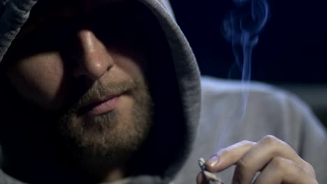 Close-up-male-portrait-smoking-marijuana-cigarette