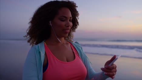 African-American-mujer-haciendo-caminar-ejercicio-con-auriculares