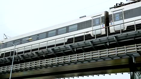 Modern-train-rushing-along-railway-bridge,-public-transportation,-urban-metro