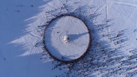 Kreis-von-Menschen,-die-während-der-Feier-des-russischen-traditionellen-Masleniza-Dummy-brennen-zu-sehen.-Filmmaterial.-Luftbild