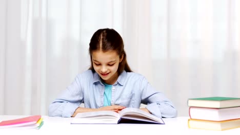 happy-school-girl-reading-book-or-textbook-at-home