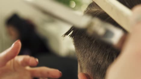 Haircutter-combing-hair-and-cutting-with-hairdressing-scissors-in-barbershop.-Close-up-hand-hairdresser-cutting-wet-male-hair-with-hairdressing-scissors-in-beauty-salon