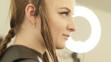 Beautiful-woman-with-clamp-for-fixing-long-hair-during-haircutting-in-hairdressing-salon.-Close-up-portrait-woman-hair-model-in-beauty-studio