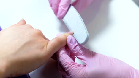 closeup-beautician-filing-nails-to-customer-in-beauty-salon