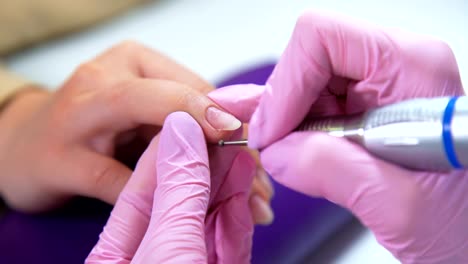 Beautician-careful-and-accurate-removing-cuticles-with-polish-machine