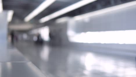 Blurred-footage-of-passengers-walking-through-the-walkway-corridor-to-airport-terminal.-4K-video-with-defocused-effect.