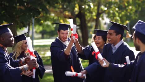 glückliche-Schüler-in-Mörtel-Boards-mit-Diplomen