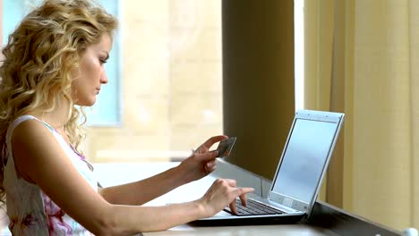 woman-holding-in-a-dress-a-credit-card-and-using-computer-keyboard-for-online-shopping