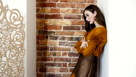 girl-model-in-high-heeled-shoes-and-fashionable-clothes-stands-near-brick-wall-posing-for-camera