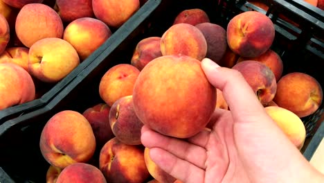 Young-man-picking-peaches-in-the-supermarket