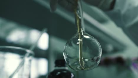 Laboratory-worker-pours-the-chemical-liquid-into-the-flask