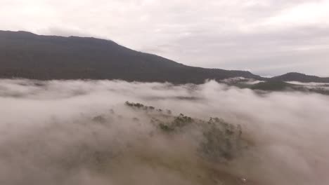 Low-clouds-and-fog-cover-Australian-farm-in-early-morning,-drone