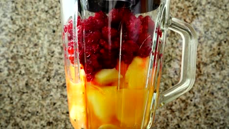 Preparation-of-cocktail-in-the-blender-from-apples,-bananas-and-raspberry.	Slow-motion.